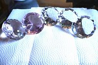 Five glass diamonds on paper towel showing colors and facets