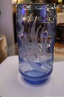 Full view of blue glass vase with etched floral design