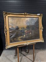 Full view of framed oil painting on easel