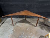 Full view of triangular table showing legs and shape