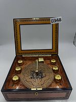 Open music box showing eight brass bells, disc, and missing adapter port