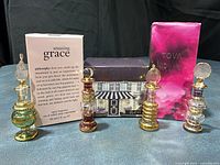 Lot overview showing 4 glass perfume bottles, 2 boxed spray fragrances, 1 boxed sugar scrub