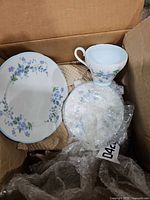 Box containing Royal Adderley plate, cup, wrapped dishes