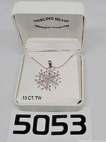 Entire necklace in open box showing snowflake pendant and chain