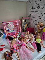 Overview of loose Barbie dolls, carrying case, boxed doll, accessories