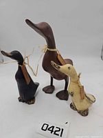 Front view of three carved wood ducks with tags