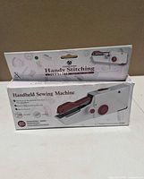 Front view of two boxed Chensheng Handy Stitching handheld sewing machines