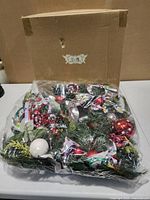 One wreath partially unwrapped showing decorations and original box
