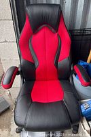 Front view of black and red adjustable gaming chair showing upholstery, armrests and backrest
