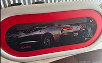 Overall view of custom Corvette poker table top with red trim and graphic
