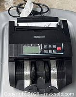 Top view of DOMENS currency counter showing display, keypad, bill paths and attached cord