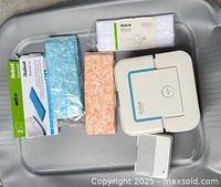 Robot mop, battery and four packs of cleaning pads displayed in tray
