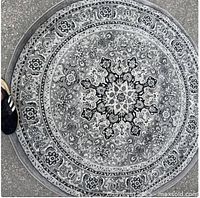 Top-down view of entire round grey ornate rug