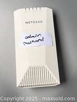 Front view of Netgear white router with ventilation grill and label