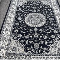 Full view of black and cream floral area rug showing central medallion and border