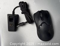 Top view of Razer Viper Ultimate mouse beside its charging dock and USB cable