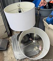 Both gray ceramic table lamps, one shade removed to show socket and harp