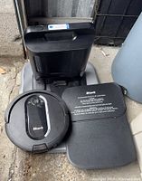 Robot vacuum, self-empty dock, and cover panel grouped together
