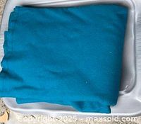 Folded teal blanket or throw on tray