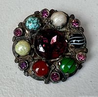 front view showing centre glass stone and surrounding cabochons