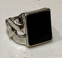 Front view of ring showing rectangular onyx and silver-tone setting