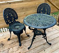 Full view of cast aluminum table and two chairs on deck