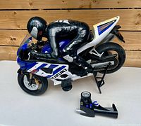 Side view of Suzuki RC motorcycle with rider and remote