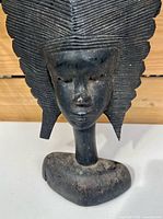 Front view of bust showing face, neck and headdress texture