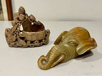 Elephant head carving and carved bowl side by side