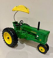 Left side view of John Deere 70 diecast tractor showing canopy, engine details, tires