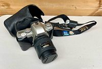 Front angled view of Pentax MZ-5 with lens, cap, strap and half-case