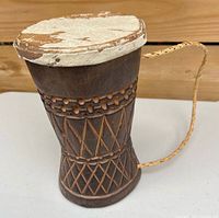 Full view of drum showing shape, carvings, strap and drumhead wear
