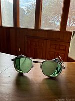 Front view of green-lens safety glasses on tabletop