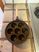 Top view showing seven wells of the cast iron pan with attached wood handle