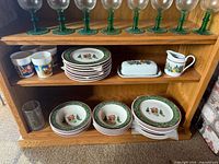 Shelved set showing goblets, plates, mugs, butter dish, creamer, bowls and tumbler