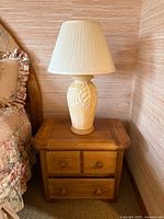 Full view of lamp on nightstand showing base and shade