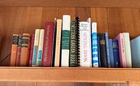 Shelf of approximately 18 vintage books showing full range of titles and spine colors