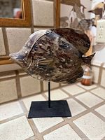 front angled view of carved wooden fish on stand showing overall form and finish