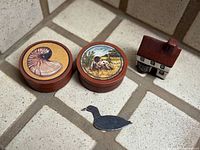 Group shot of two trinket boxes, ceramic cottage and duck silhouette