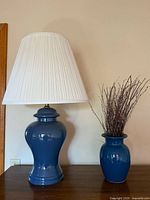 Lamp and vase together on wooden surface