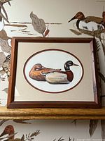 Full view of framed duck print on wall