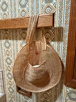 Round woven straw shoulder bag with straps and hat inserted