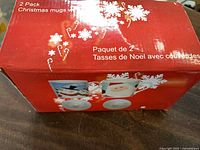 Retail box showing 2-pack Christmas mugs with lids