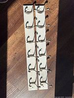 Both white coat racks laid flat showing full length and hooks