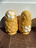 Yellow Florida souvenir shakers with raised white flowers