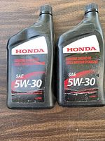 Front view of two sealed 1 L Honda 5W-30 engine oil bottles