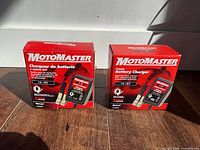 Front view showing two MotoMaster charger retail boxes