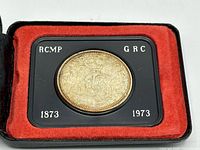 Reverse side of coin showing mounted officer, RCMP / GRC insert, years 1873-1973