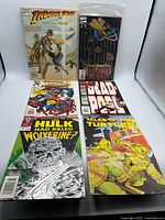 Six comics laid out on lightbox surface