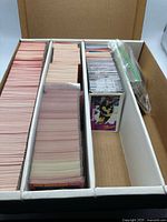 Three-row card storage box filled with hockey cards and bag of extras